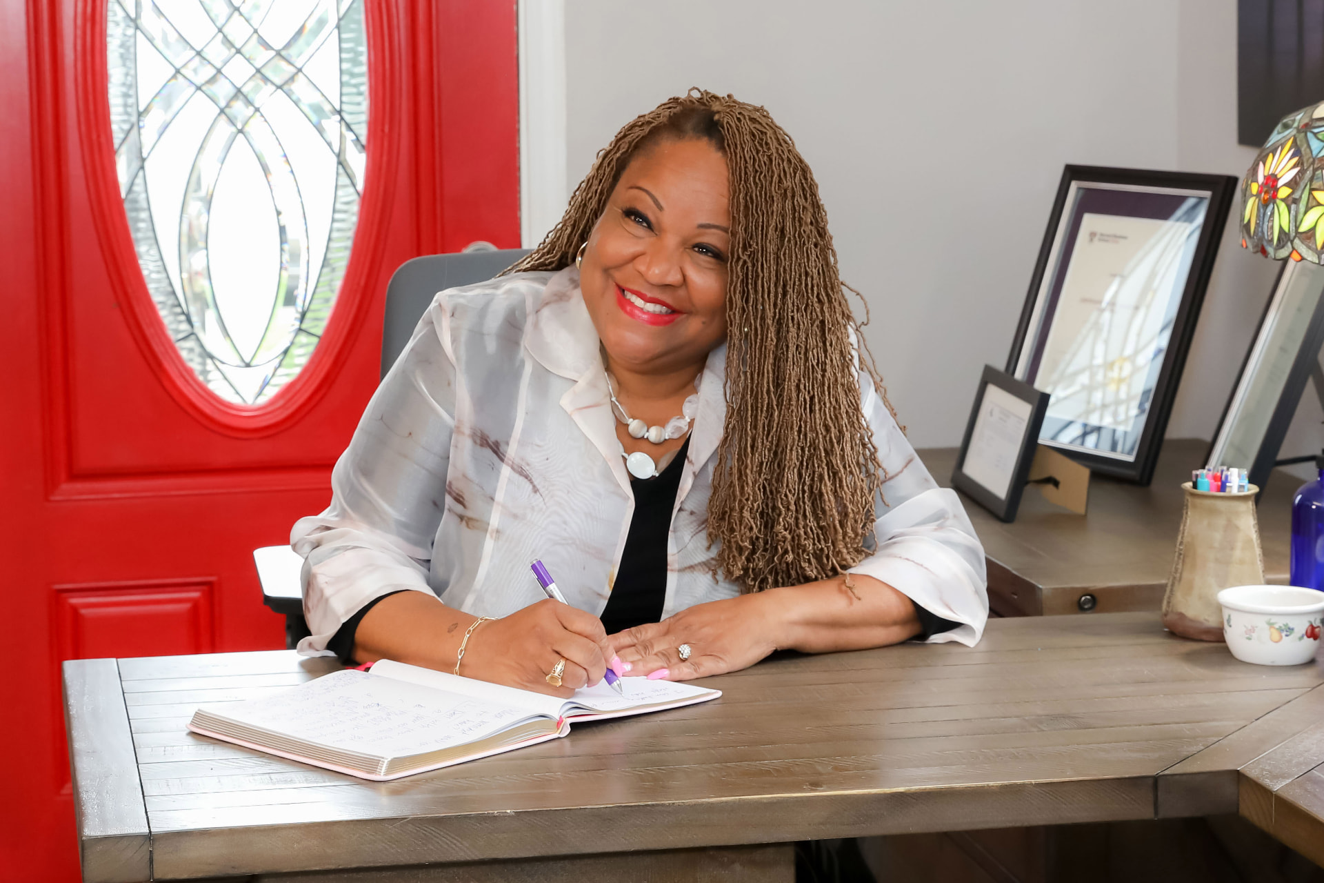 Lynell Renee Green writing in a notebook at her desk